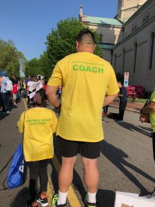 A coach for Kids Run RVA stands with one of the student run club participants