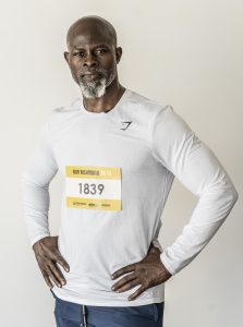 Djimon Hounsou poses for a photo wearing a race bib for Run Richmond 16.19