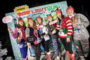 A group of six Tacky Light Run participants pose for a photo before the event.
