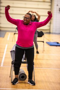 A woman smiles while exercising in a Fitness Warriors class