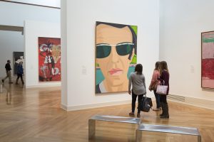 Interior photo of people looking at a painting in the Virginia Museum of Fine Arts