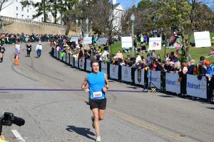 A photo of Rob Waddell preparing to cross the finish line in the 2021 Richmond Marathon