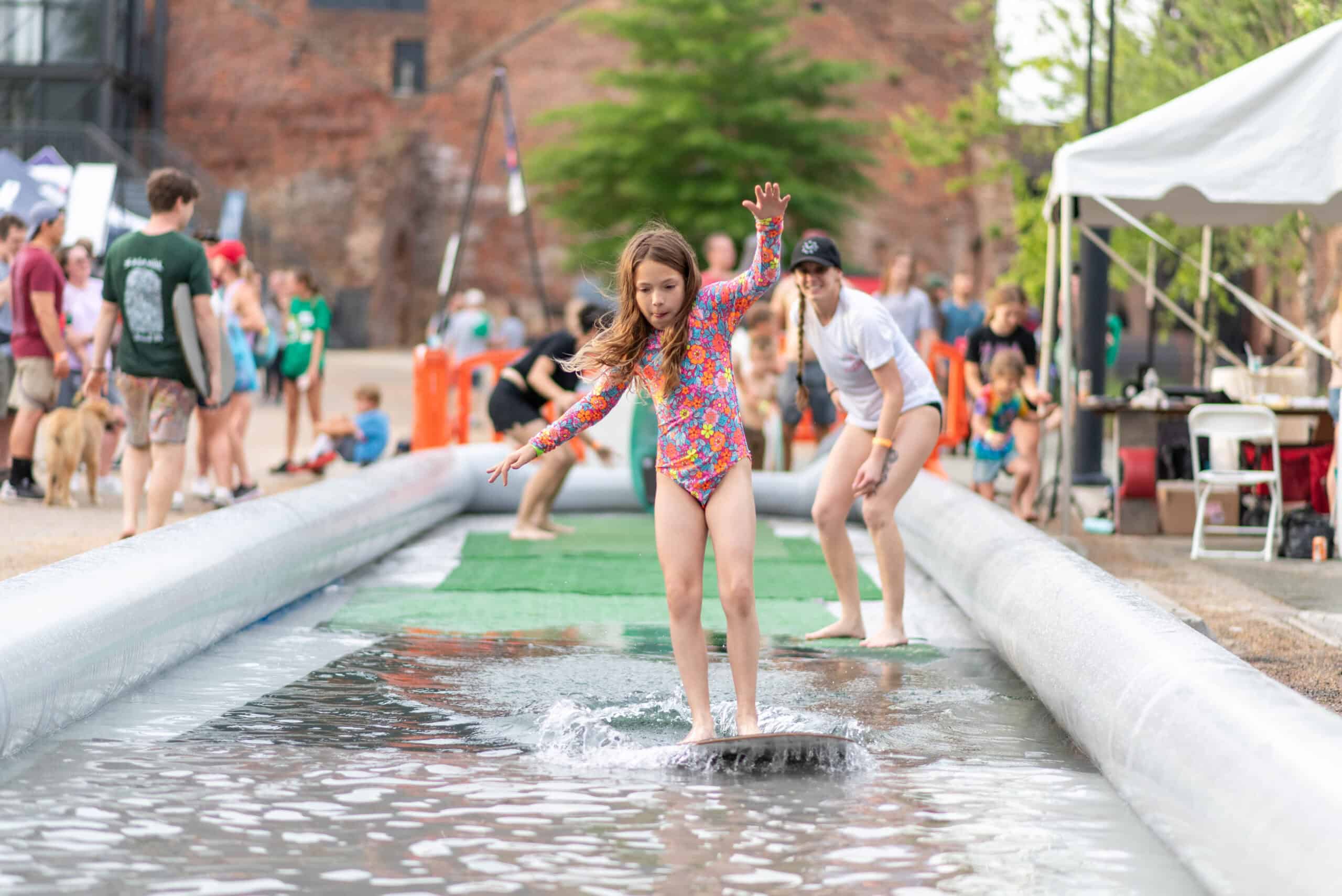 Kids try out skim boards at one of the Adventure Zones